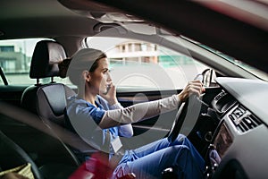 Female nurse going home from work, getting into car. Female doctor driving car to work, on-call duty, phone calling