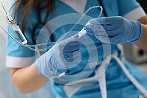 Female nurse hand in blue protective gloves hold dropper