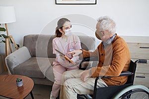 Female Nurse Helping Disabled Senior Man with Technology