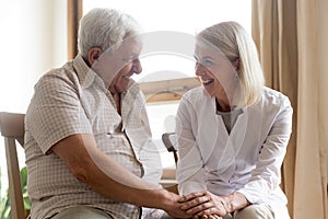 Female nurse hold hands supporting senior male patient