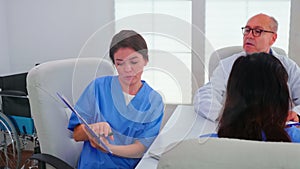 Female nurse holding clipboard explaining diagnosis