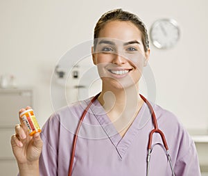 Female nurse holding out bottle of medication