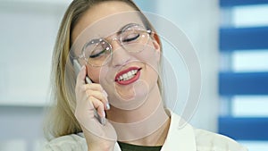 Female nurse at hospital reception talking on the phone