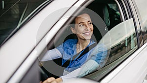 Female nurse sitting in car, going home from work. Female doctor driving car to work, on-call duty. Work-life balance of