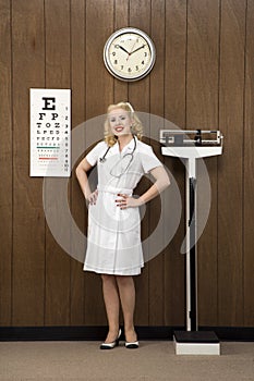 Female nurse standing in retro setting.