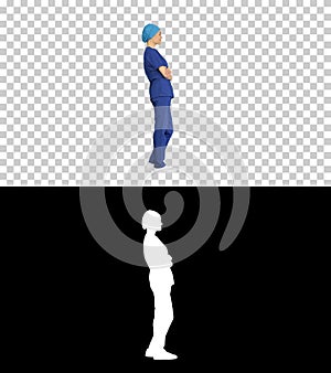 Female nurse or surgeon wearing blue suit standing and waiting,