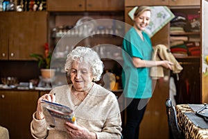 Female nurse taking care of a senior woman at home