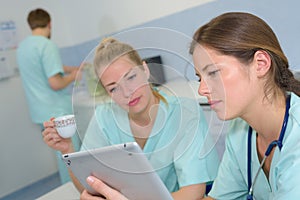 female nurse vets checking tablet at lunch break