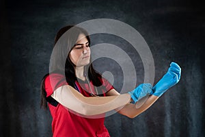 Female nurse wear red uniform putting on blue gloves