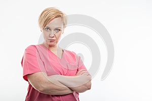 Female nurse wearing pink scrubs standing with arms crossed