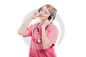 Female nurse wearing scrubs enjoying listening music