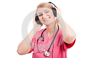 Female nurse wearing scrubs listening to headset