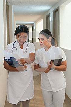 Female nurses talking while walking on hospital