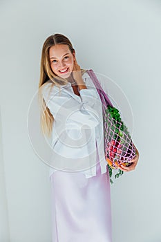 Female nutritionist holding bag with vegetables for cooking
