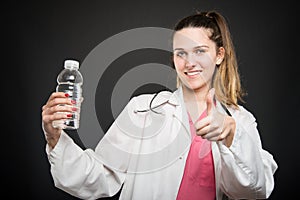 Female nutritionist pointing bottle of water showing like