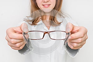 Female oculist doctor giving glasses to patient