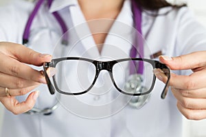 Female oculist doctor hands giving pair of glasses. Good vision