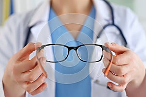 Female oculist doctor hands giving pair of glasses. Good vision