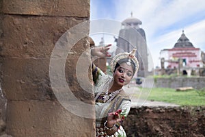 Female odissi dancer posing in front of Temple in bhubaneswar, Odisha, India