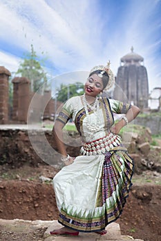 Female odissi dancer posing in front of Temple in bhubaneswar, Odisha, India