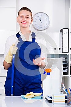 Female office cleaner is talking while cleaning the cabinet