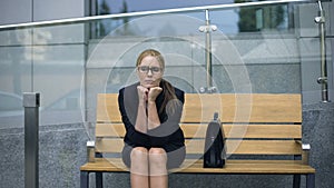 Female office employee sitting on bench, worrying bout troubles at work, stress