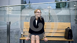 Female office employee sitting on bench, worrying bout troubles at work, stress