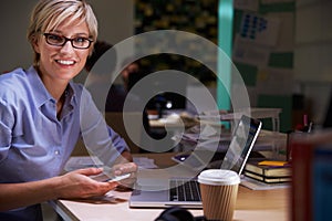 Female Office Worker With Coffee At Desk Working Late