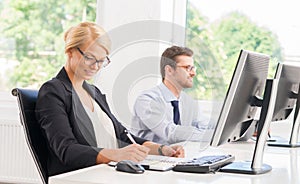 Female office worker in formalwear with her colleague