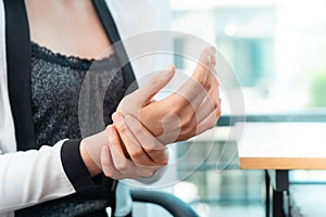 Female office worker having office syndrome injury on her wri