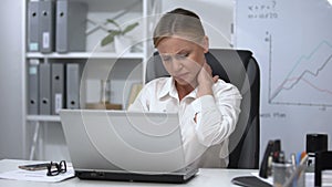 Female office worker massaging numbing neck, sedentary life result, spasm