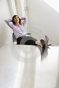 Female office worker relaxing, feet up on table