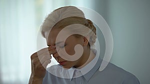 Female office worker removing glasses, feeling eye pain, stress and exhaustion