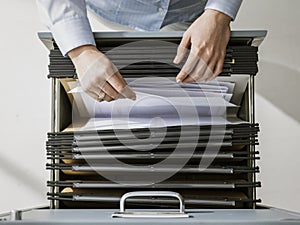 Office worker searching files in the archive photo