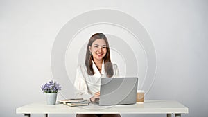 Female office worker sits at her desk. isolated white studio background