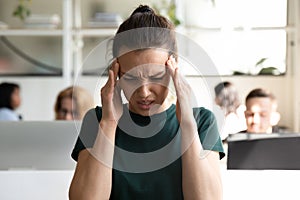 Female office worker suffers from sudden throbbing headache