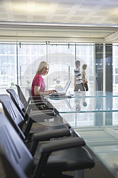 Female Office Worker Using Laptop In Conference Room