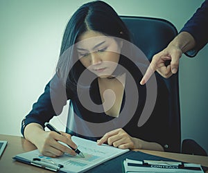 Female office worker working under pressure from supervisor