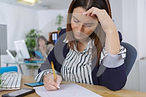 Female office worker writing something on paper