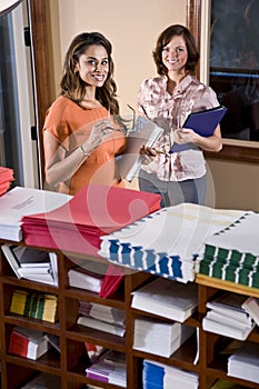 Female office workers standing in mailroom