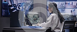 Female officer works on computer in police monitoring center