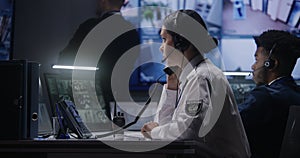 Female officer works on computer in police monitoring center