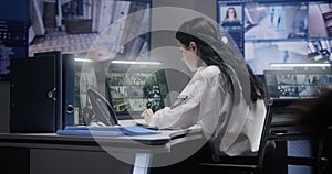 Female officer works on computer in police monitoring center