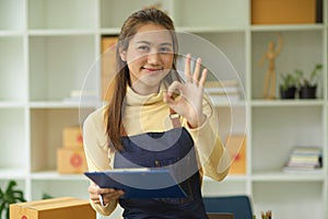 Female online business owner doing an OK hand sign