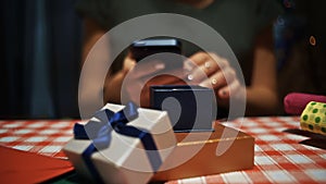 Female opening a small blue secret present box and taking a photo on smartphone