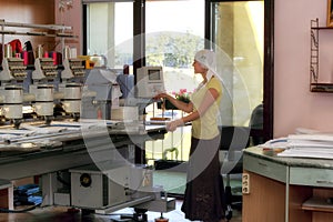 Female operator of automatic embroidery machines