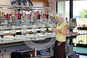 Female operator of automatic embroidery machines
