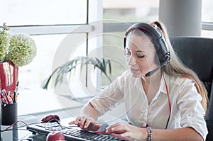 Female operator in the call center, working in office.