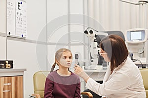 Female Ophthalmologist Examining Little Girl