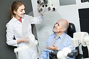 Female ophthalmologist and mature patient checking eyesight in c
